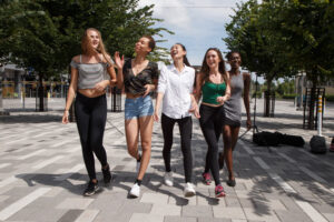 Five young women walking through Lansdowne, laughing and shopping.