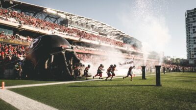 Image of REDBLACKS players exiting the tunnel on the field at the start of a game